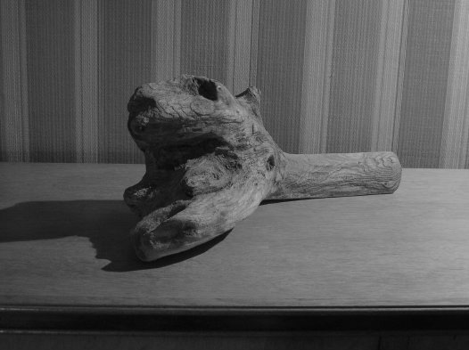 wooden head on sideboard lit by 1977 Tizio